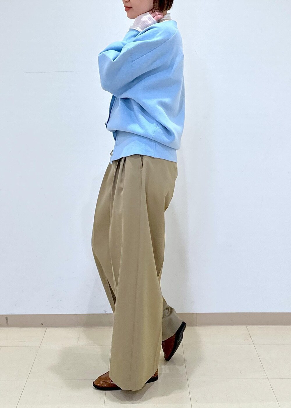 ブラウン系のローファー、ブルー系のカーディガン/ボレロ、ホワイト系のニット/セーターを着用したレディースの冬コーディネートの9枚目の写真