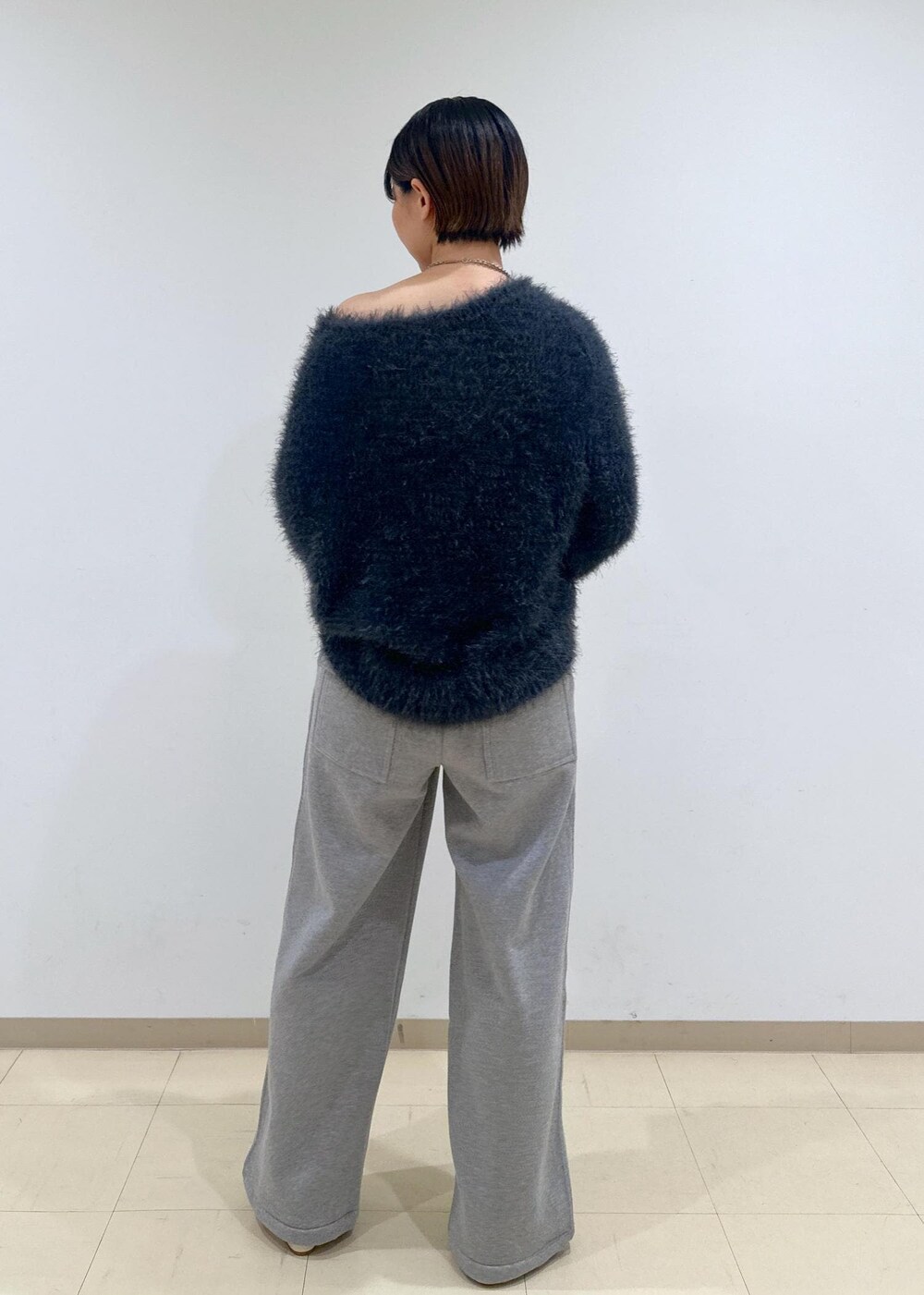 ホワイト系のパンプス、グレー系のニット/セーター、シルバー系のショルダーバッグを着用したレディースの秋コーディネートの4枚目の写真
