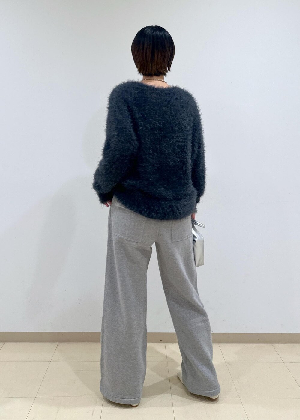 ホワイト系のパンプス、グレー系のニット/セーター、シルバー系のショルダーバッグを着用したレディースの秋コーディネートの6枚目の写真