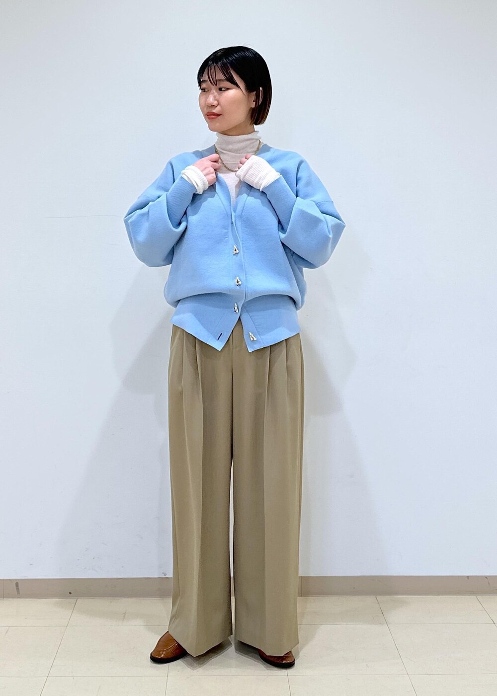 ブラウン系のローファー、ブルー系のカーディガン/ボレロ、ホワイト系のニット/セーターを着用したレディースの冬コーディネートの7枚目の写真