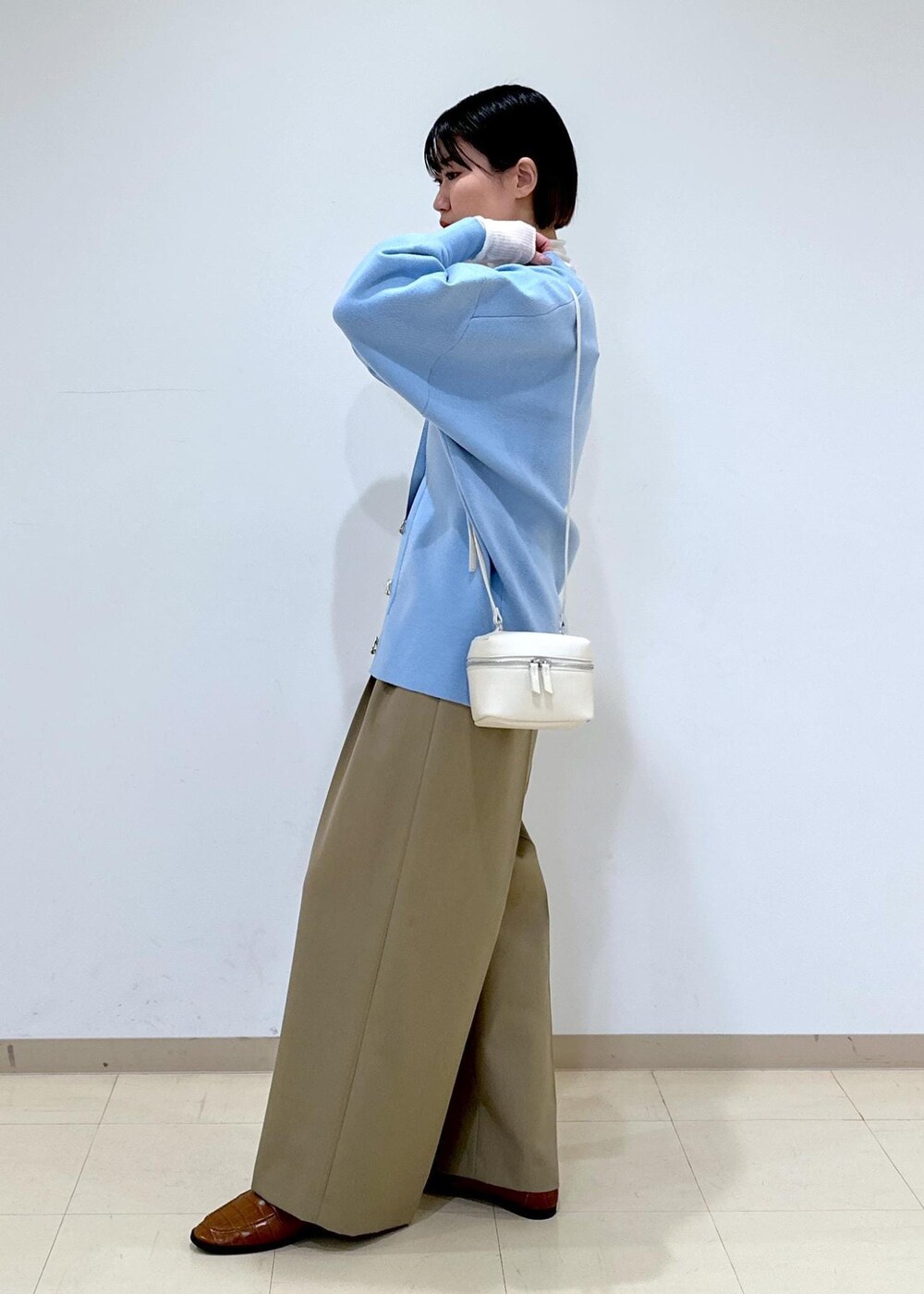 ブラウン系のローファー、ブルー系のカーディガン/ボレロ、ホワイト系のニット/セーターを着用したレディースの冬コーディネートの3枚目の写真