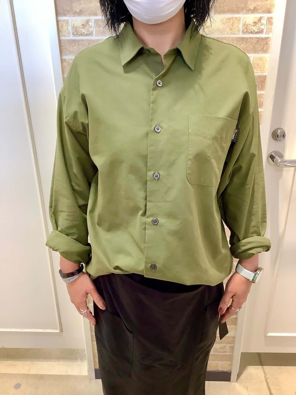 グリーン系のシャツ/ブラウスを着用したレディースの秋コーディネートの2枚目の写真