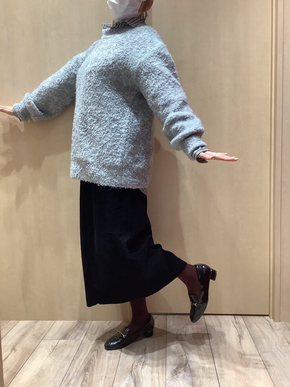 グレー系のニット/セーター、グレー系のシャツ/ブラウスを着用したレディースの冬コーディネートの3枚目の写真