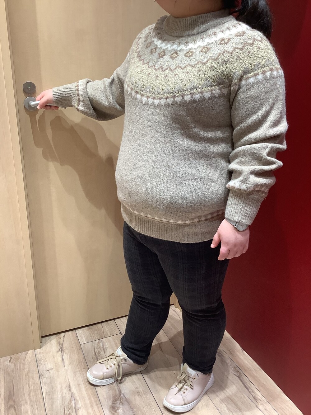 ブラウン系のニット/セーターを着用したレディースの冬コーディネートの2枚目の写真