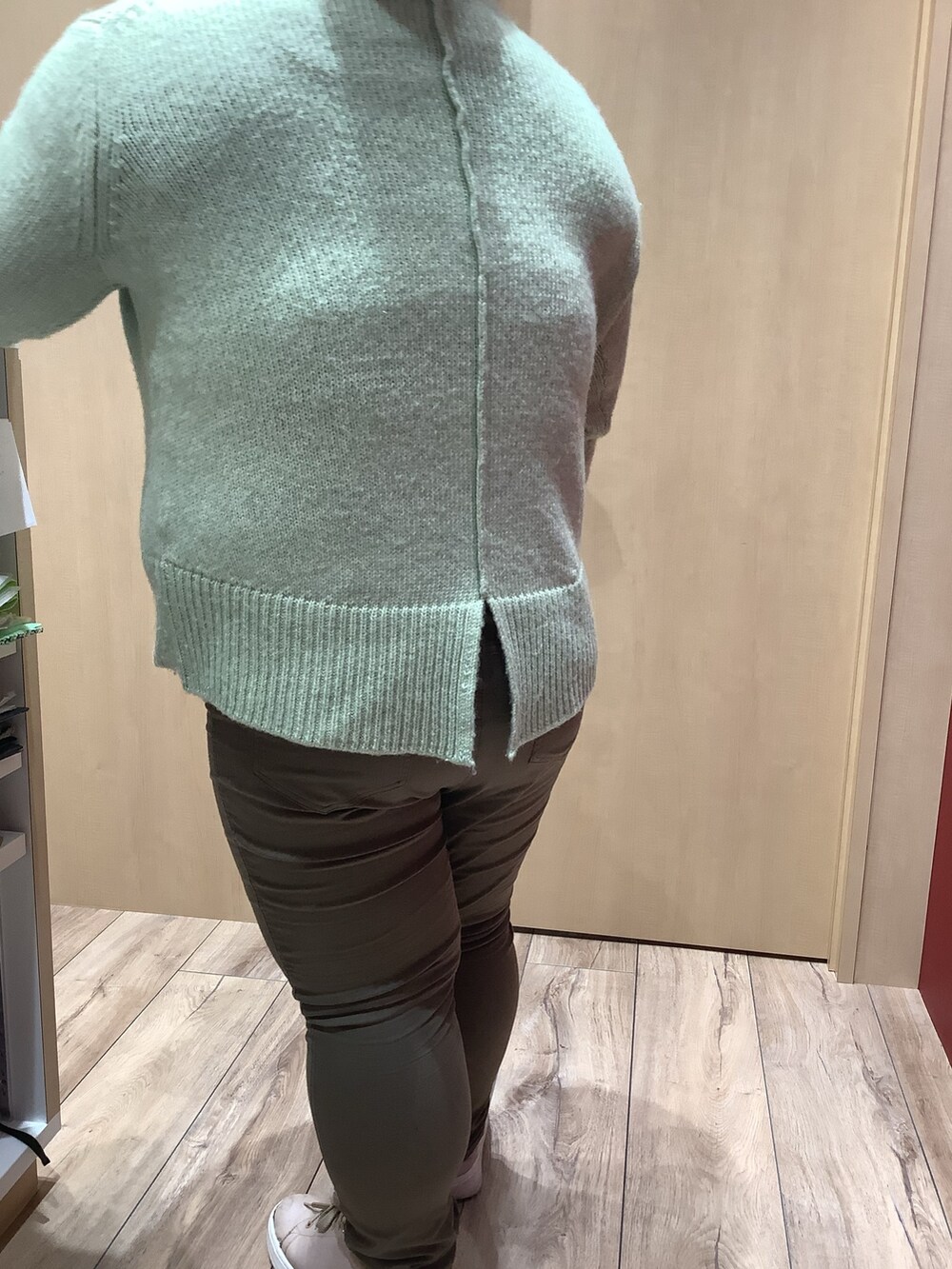 グリーン系のニット/セーターを着用したレディースの冬コーディネートの2枚目の写真