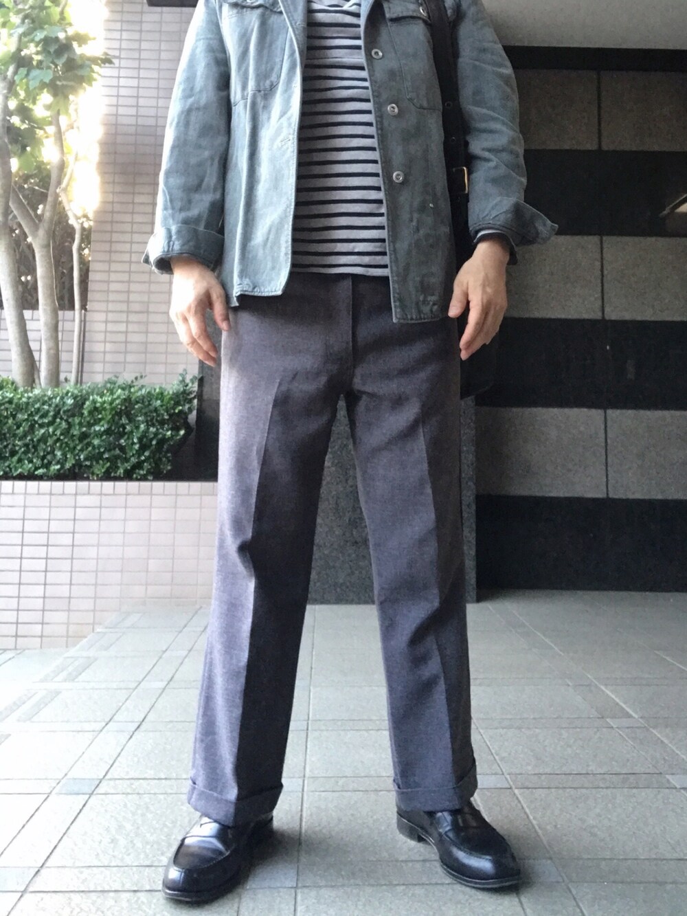 グレー系のミリタリージャケット、その他のTシャツ/カットソー、グレー系のスラックスを着用したメンズの夏コーディネートの3枚目の写真