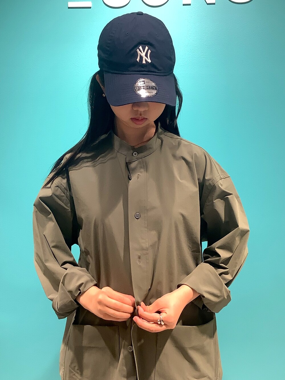 グリーン系のシャツ/ブラウスを着用したレディースの夏コーディネートの2枚目の写真