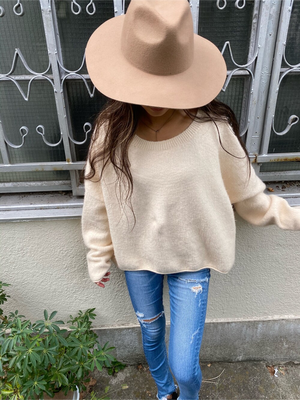 ブルー系のデニムパンツ、ホワイト系のニット/セーター、ベージュ系のハットを着用したレディースの秋コーディネートの4枚目の写真