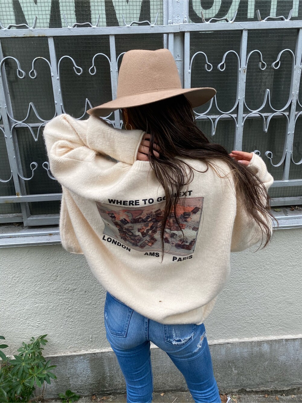 ブルー系のデニムパンツ、ホワイト系のニット/セーター、ベージュ系のハットを着用したレディースの秋コーディネートの5枚目の写真