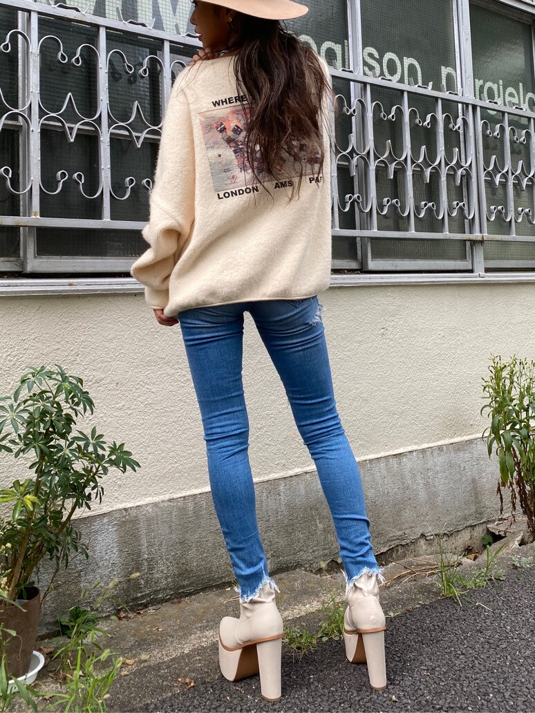 ブルー系のデニムパンツ、ホワイト系のニット/セーター、ベージュ系のハットを着用したレディースの秋コーディネートの3枚目の写真