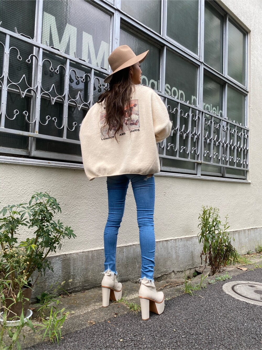 ブルー系のデニムパンツ、ホワイト系のニット/セーター、ベージュ系のハットを着用したレディースの秋コーディネートの2枚目の写真