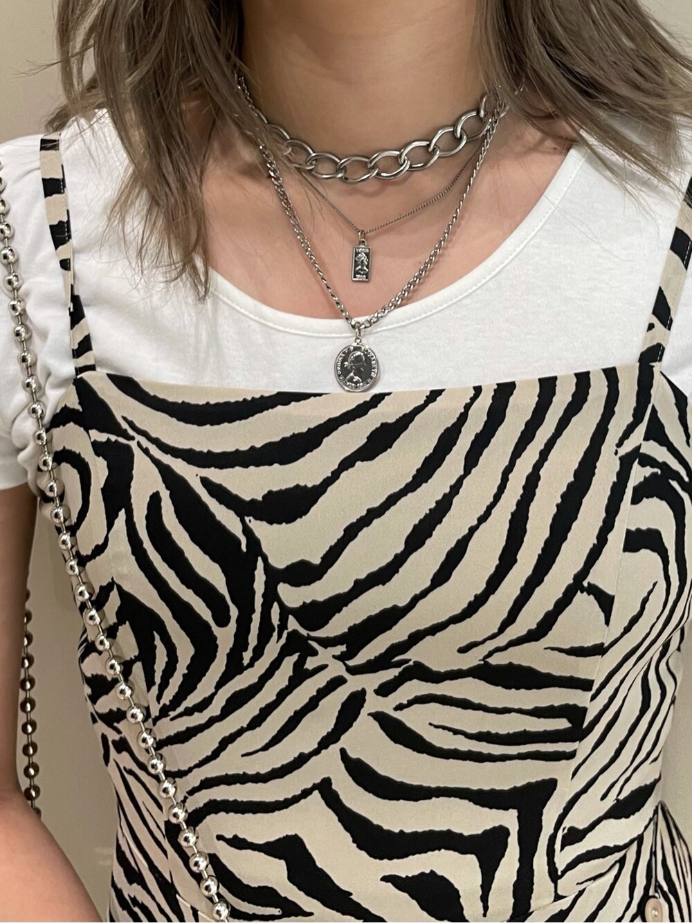 ホワイト系のTシャツ/カットソー、ホワイト系のサンダル、シルバー系のネックレスを着用したレディースの春コーディネートの4枚目の写真