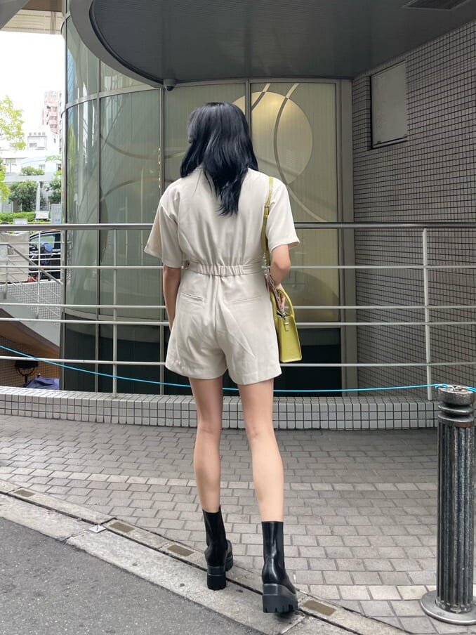 ホワイト系のつなぎ/オールインワン、ブラック系のブーツ、イエロー系のショルダーバッグを着用したレディースの春コーディネートの2枚目の写真