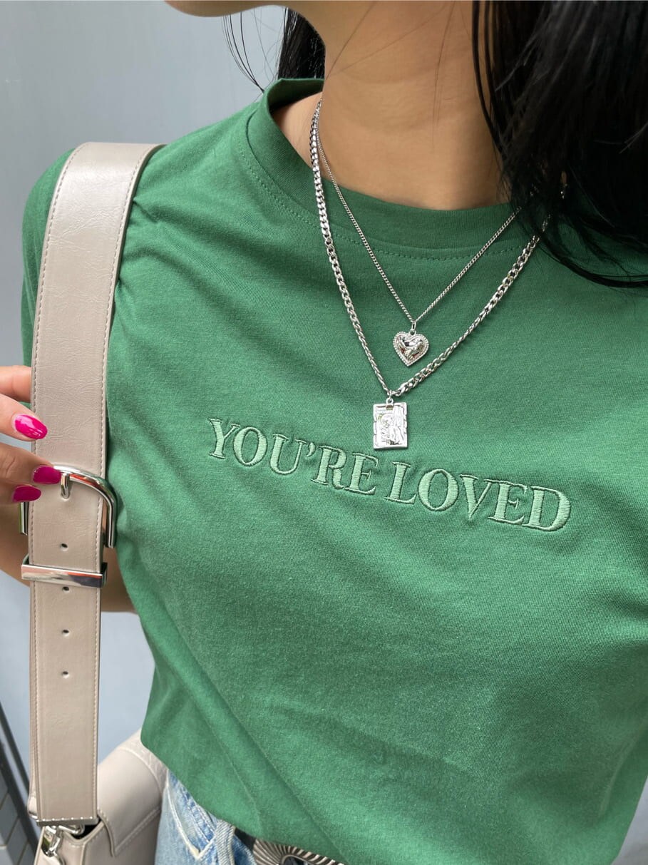 グリーン系のTシャツ/カットソー、ホワイト系のショルダーバッグ、ブルー系のデニムパンツを着用したレディースの春コーディネートの8枚目の写真