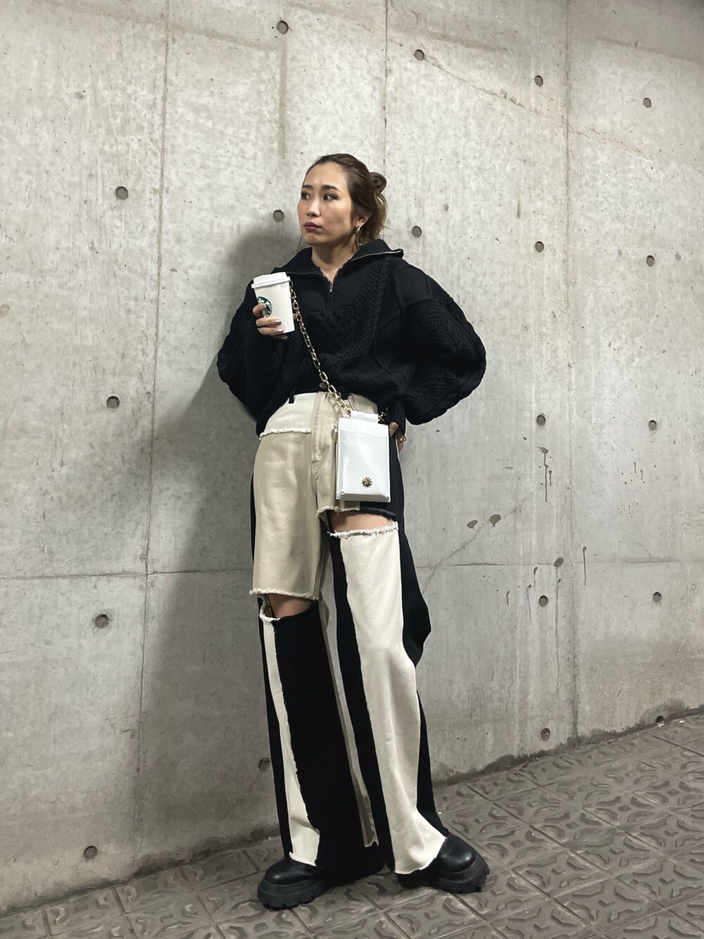 ブラック系のブーツ、ホワイト系のショルダーバッグ、ブラック系のニット/セーターを着用したレディースの冬コーディネートの2枚目の写真