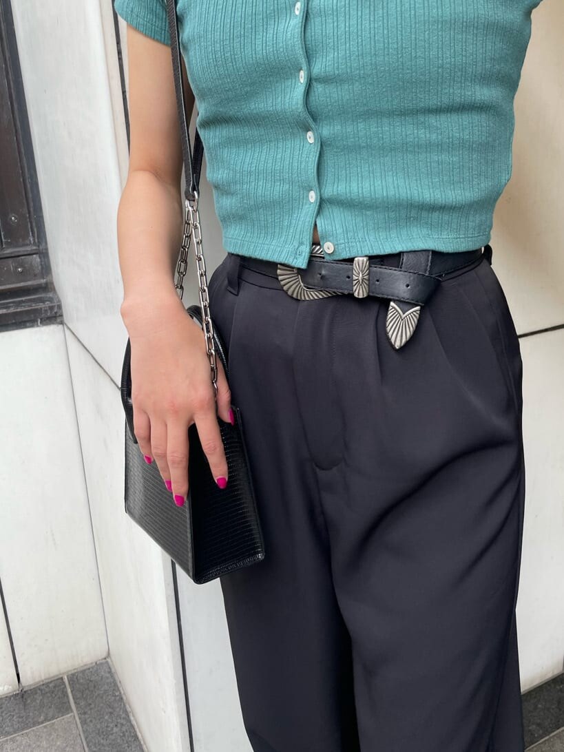 ブラック系のその他パンツ、グリーン系のTシャツ/カットソー、ブラック系のブーツを着用したレディースの春コーディネートの4枚目の写真