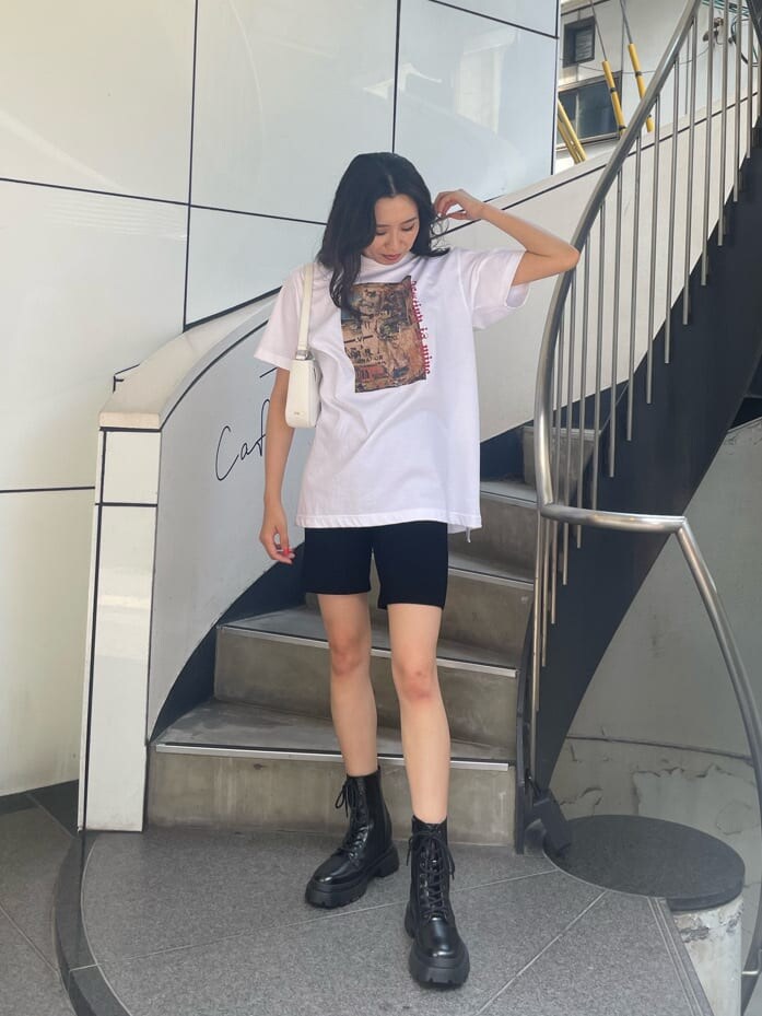 ブラック系のブーツ、ホワイト系のショルダーバッグ、ブラック系のその他パンツを着用したレディースの夏コーディネートの2枚目の写真