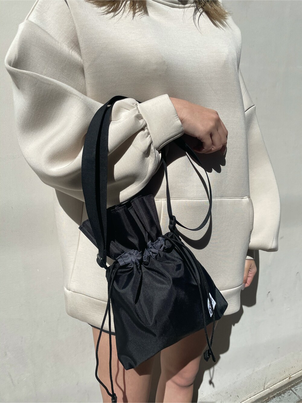 ブラック系のスカート、ブラック系のポーチを着用したレディースの春コーディネートの3枚目の写真