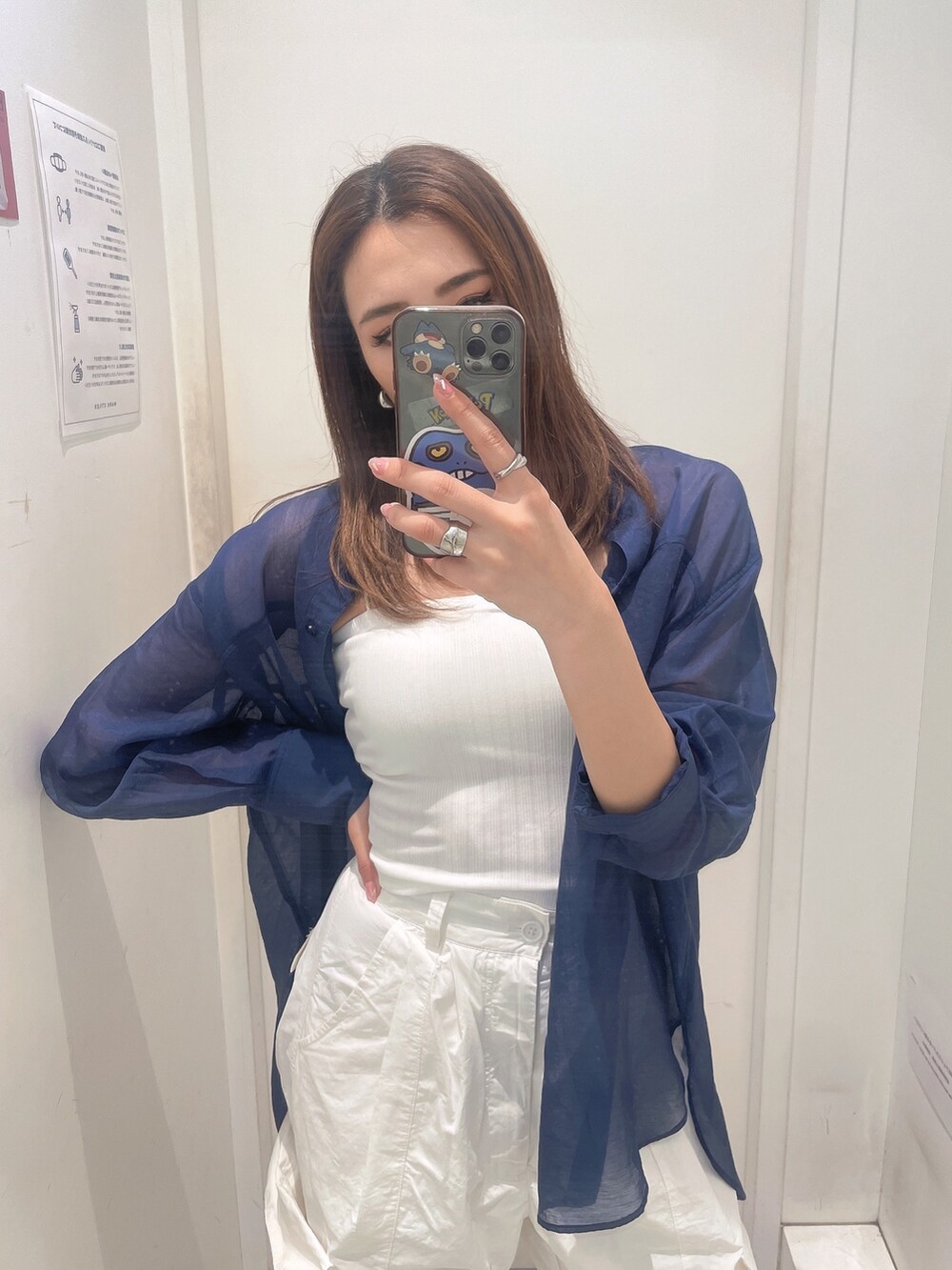 ブルー系のシャツ/ブラウス、ホワイト系のキャミソール、ホワイト系のカーゴパンツを着用したレディースの春コーディネートの2枚目の写真