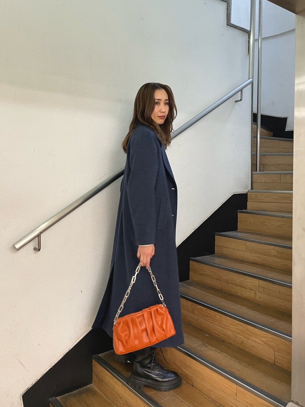 ブラック系のブーツ、ホワイト系のスウェット、ブルー系のその他アウターを着用したレディースの冬コーディネートの2枚目の写真