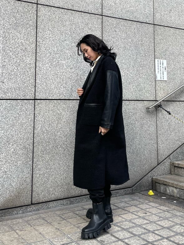 ブラック系のブーツ、ホワイト系のスウェット、ブラック系のその他アウターを着用したレディースの冬コーディネートの3枚目の写真