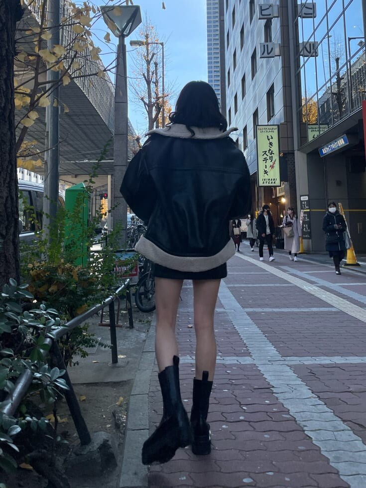 ブラック系のブーツ、ブラック系のハンドバッグ、ブラック系のブルゾンを着用したレディースの冬コーディネートの6枚目の写真