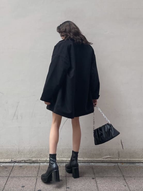 ブラック系のその他アウター、ブラック系のショルダーバッグ、ベージュ系のニット/セーターを着用したレディースの冬コーディネートの2枚目の写真