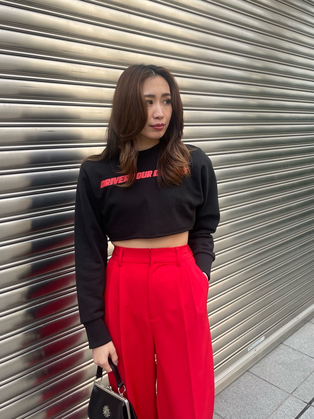 レッド系のその他パンツ、ブラック系のライダースジャケット、ブラック系のショルダーバッグを着用したレディースの春コーディネートの6枚目の写真