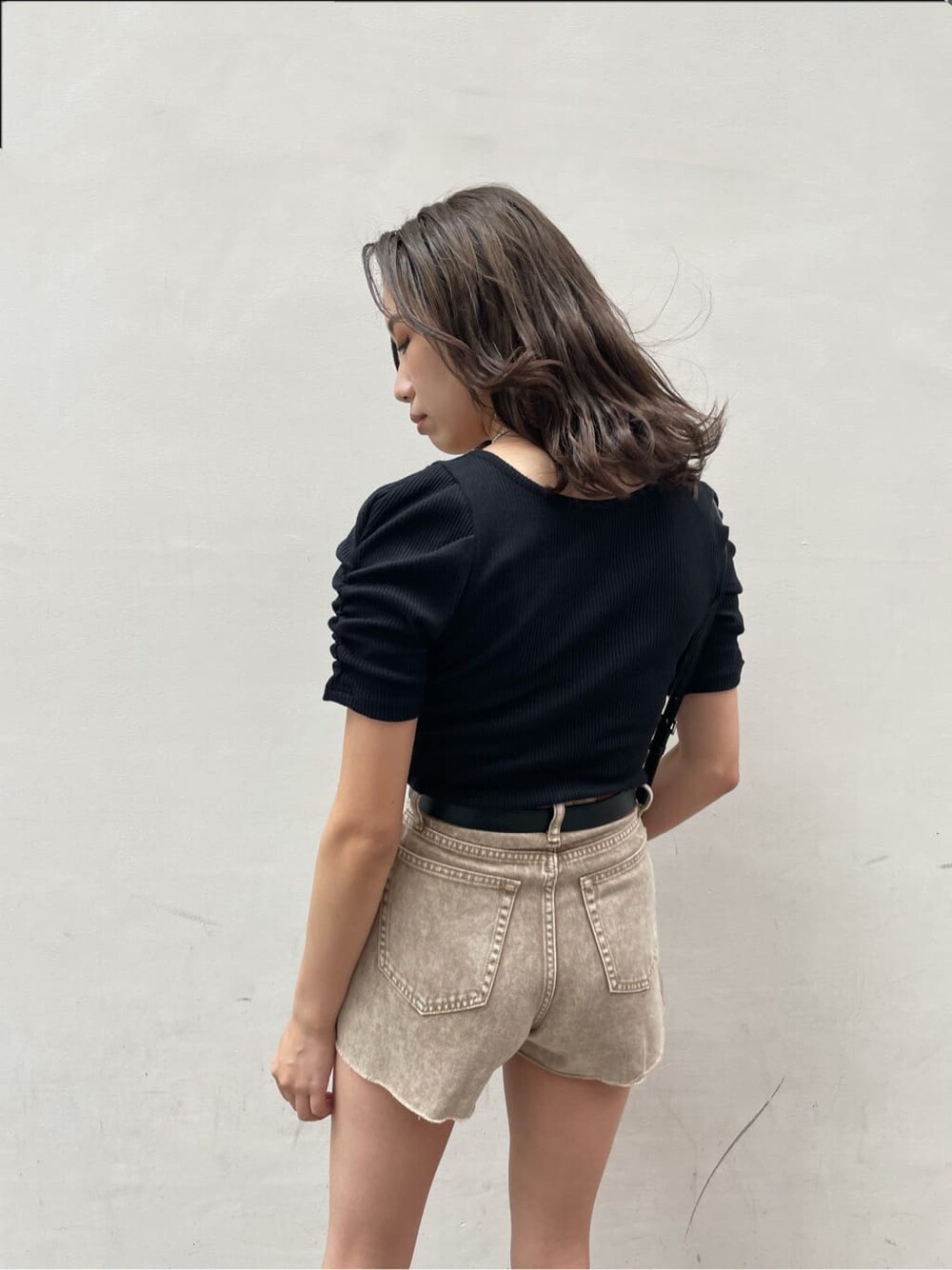 ブラック系のサンダル、ベージュ系のデニムパンツ、ブラック系のTシャツ/カットソーを着用したレディースの夏コーディネートの3枚目の写真