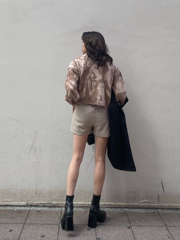 ブラック系のその他アウター、ブラック系のショルダーバッグ、ベージュ系のニット/セーターを着用したレディースの冬コーディネートの4枚目の写真