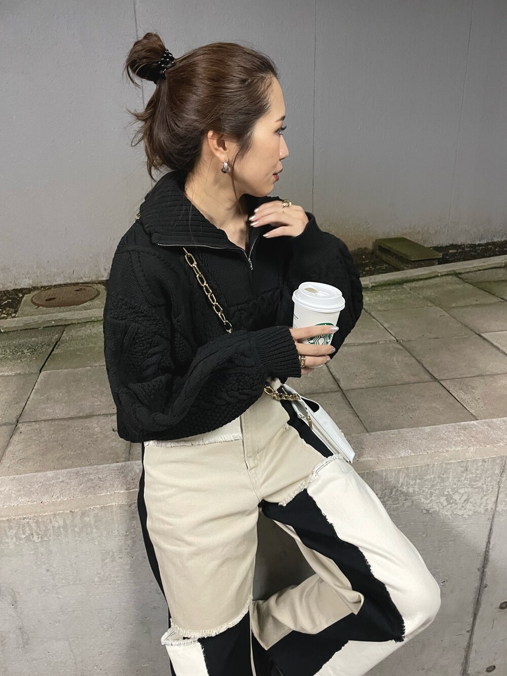 ブラック系のブーツ、ホワイト系のショルダーバッグ、ブラック系のニット/セーターを着用したレディースの冬コーディネートの5枚目の写真