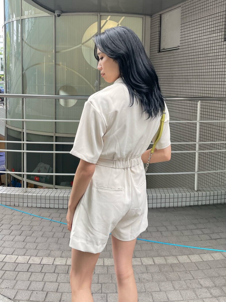 ホワイト系のつなぎ/オールインワン、ブラック系のブーツ、イエロー系のショルダーバッグを着用したレディースの春コーディネートの4枚目の写真