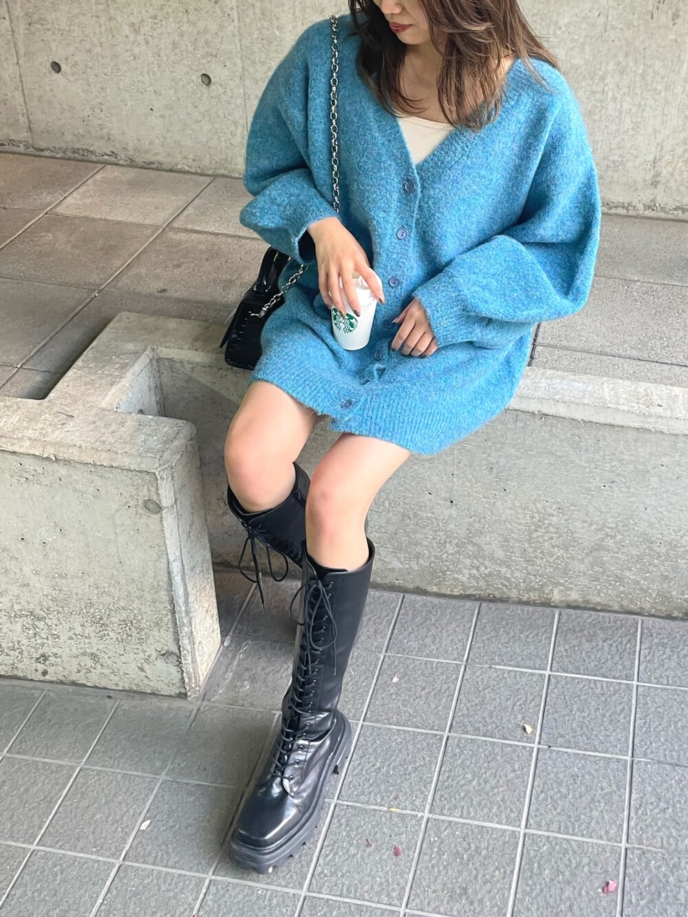 ブルー系のカーディガン/ボレロ、ブラック系のショルダーバッグ、ブラウン系のブーツを着用したレディースの秋コーディネートの6枚目の写真