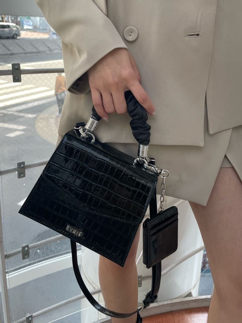 ブラック系のブーツ、ブラック系のショルダーバッグ、ブラック系のTシャツ/カットソーを着用したレディースの春コーディネートの5枚目の写真