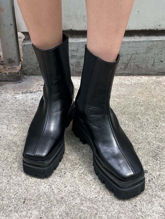 ブラック系のブーツ、ベージュ系のニット/セーター、ホワイト系のTシャツ/カットソーを着用したレディースの春コーディネートの9枚目の写真