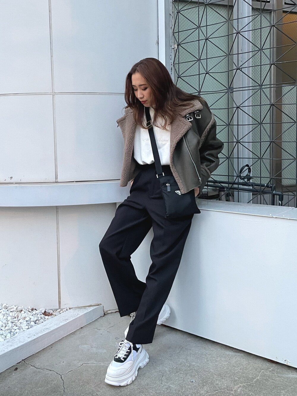 グリーン系のブルゾン、ホワイト系のスウェット、ブラック系のスラックスを着用したレディースの冬コーディネートの6枚目の写真