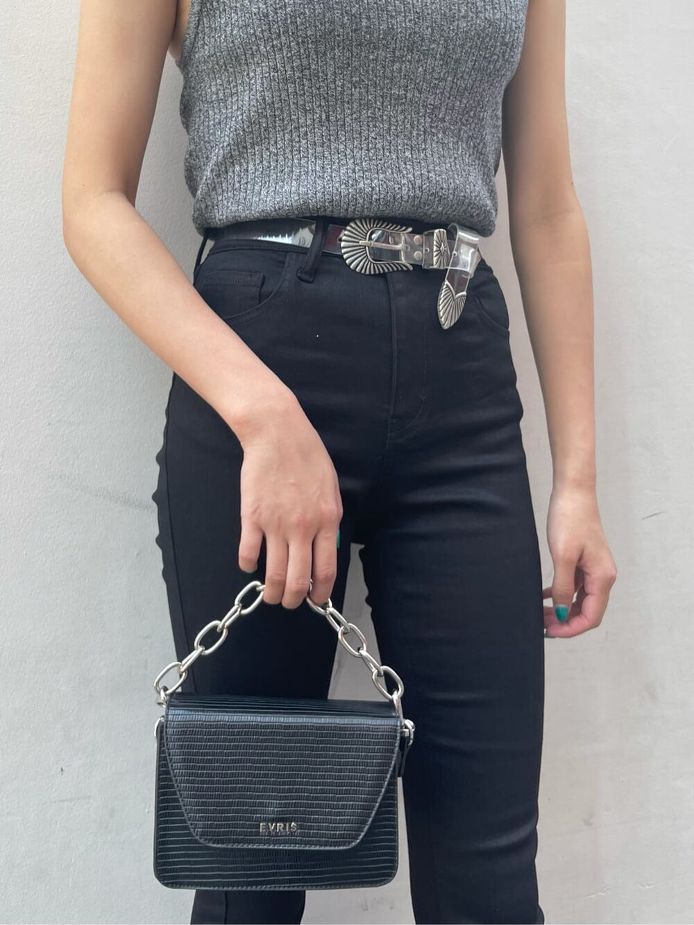 ブラック系のニット/セーター、ブラック系のブーツ、ブラック系のデニムパンツを着用したレディースの夏コーディネートの5枚目の写真