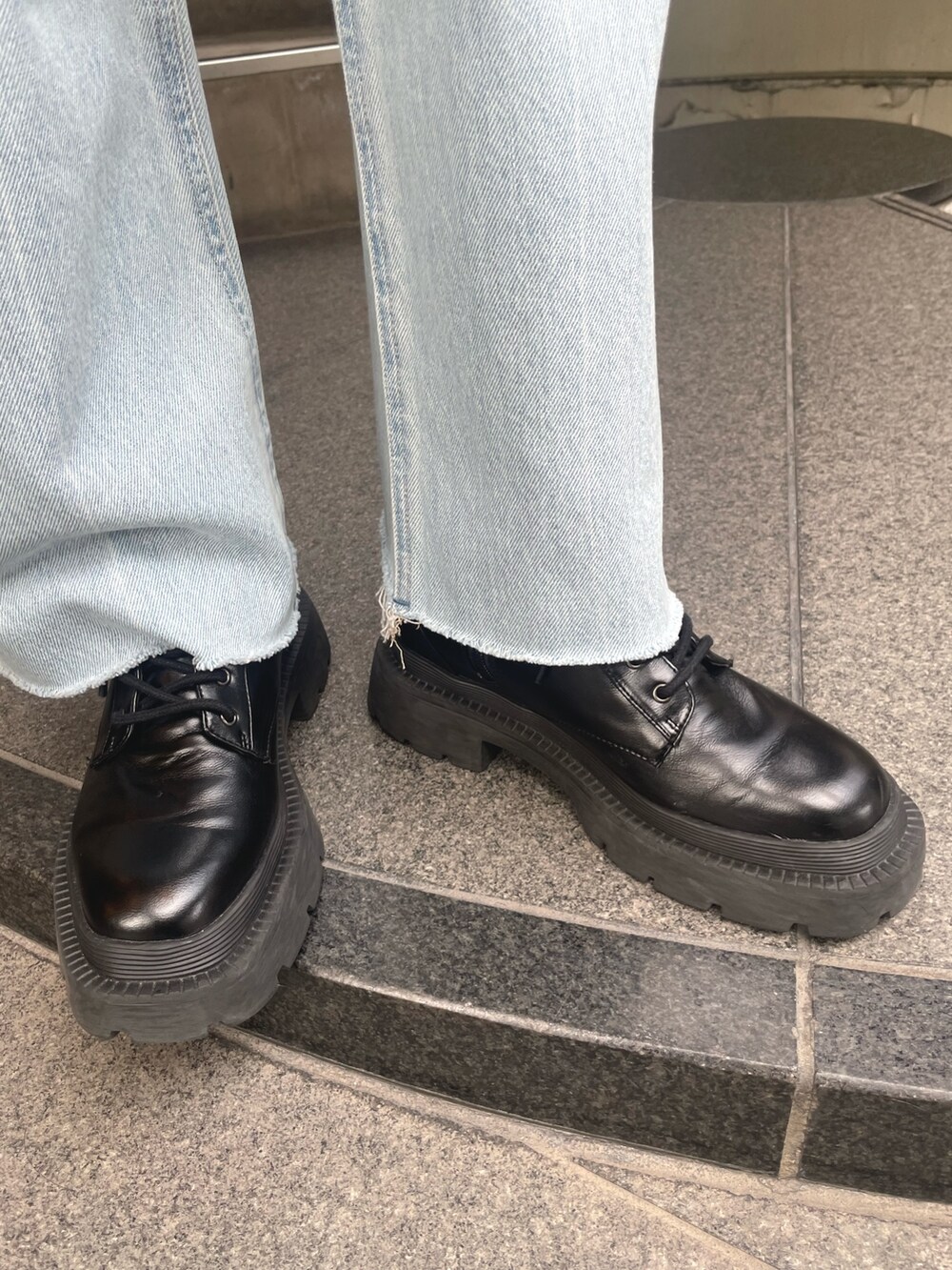 グレー系のニット/セーター、イエロー系のハンドバッグ、ブルー系のデニムパンツを着用したレディースの秋コーディネートの9枚目の写真