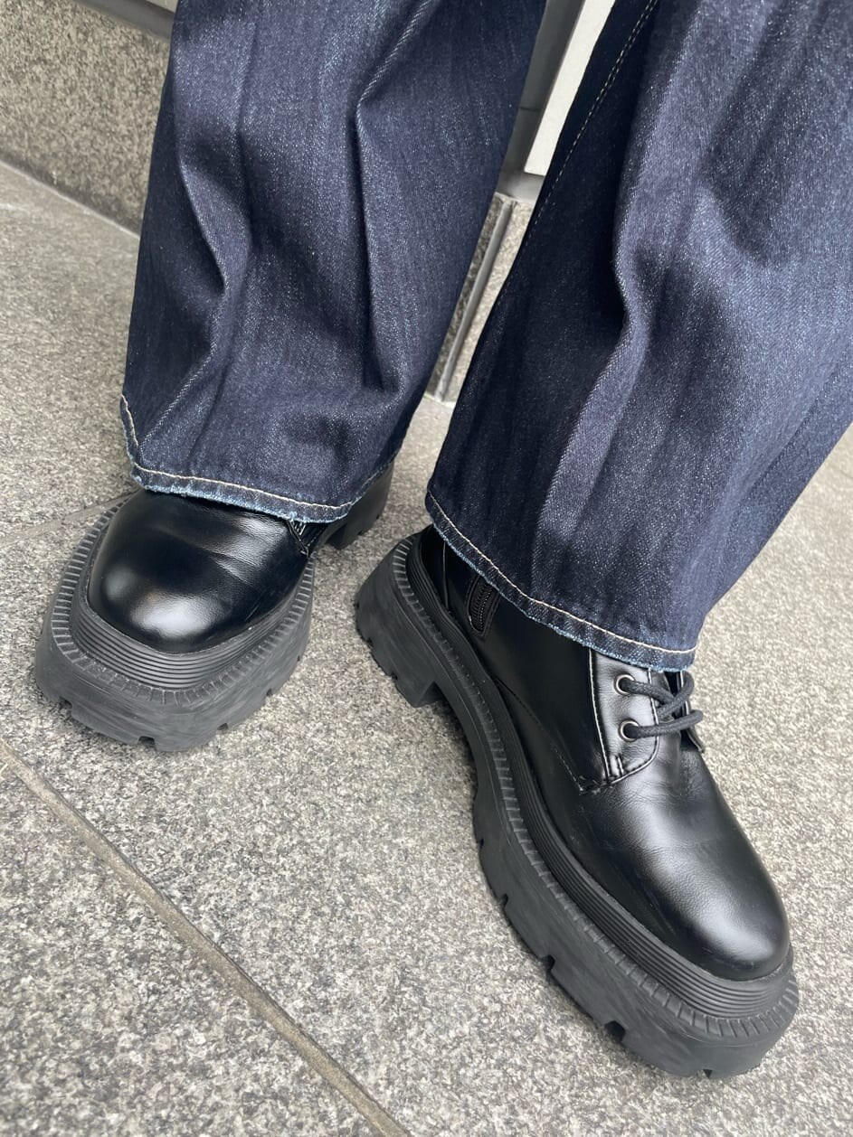 ブラック系のブーツ、ブラウン系のボストンバッグ、ブルー系のデニムパンツを着用したレディースの夏コーディネートの10枚目の写真