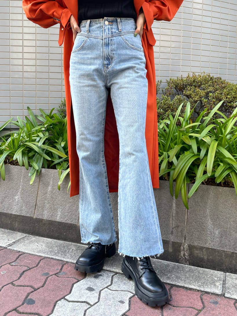 ブラック系のブーツ、オレンジ系のトレンチコート、ブルー系のデニムパンツを着用したレディースの春コーディネートの8枚目の写真