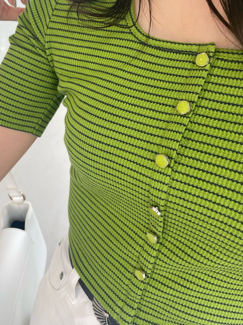 グリーン系のTシャツ/カットソー、ホワイト系のショルダーバッグ、ホワイト系のデニムパンツを着用したレディースの春コーディネートの7枚目の写真