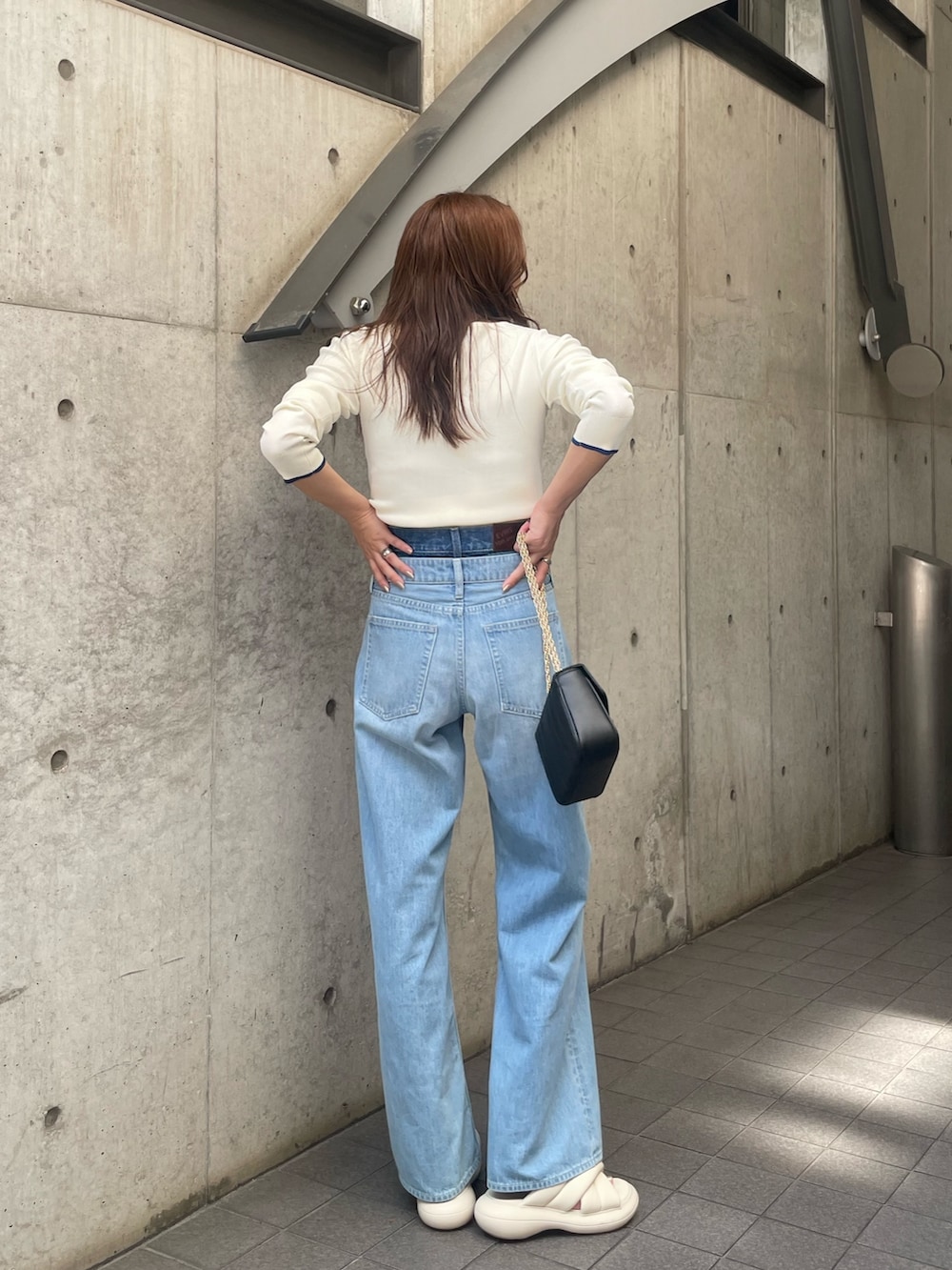 ホワイト系のニット/セーター、ブルー系のデニムパンツ、ブラック系のショルダーバッグを着用したレディースの夏コーディネートの7枚目の写真