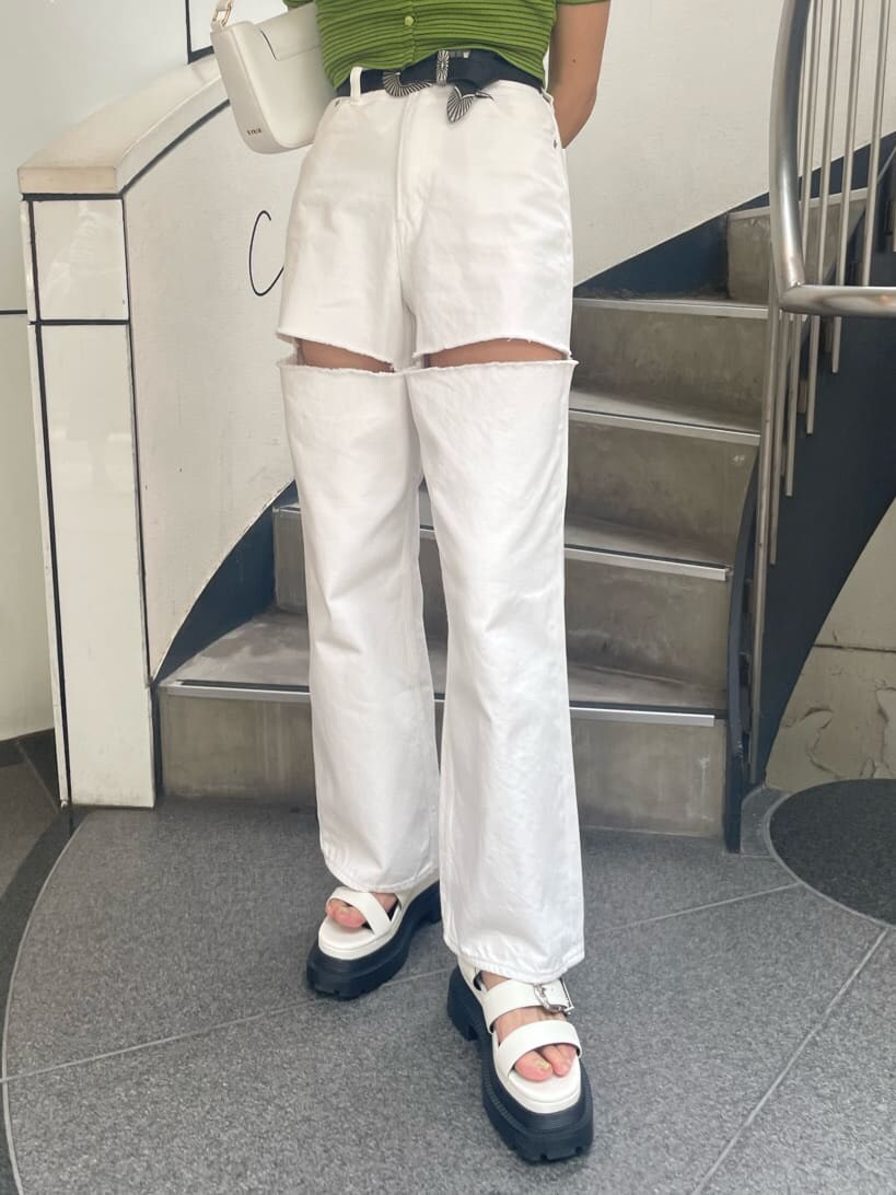 グリーン系のTシャツ/カットソー、ホワイト系のショルダーバッグ、ホワイト系のデニムパンツを着用したレディースの春コーディネートの6枚目の写真