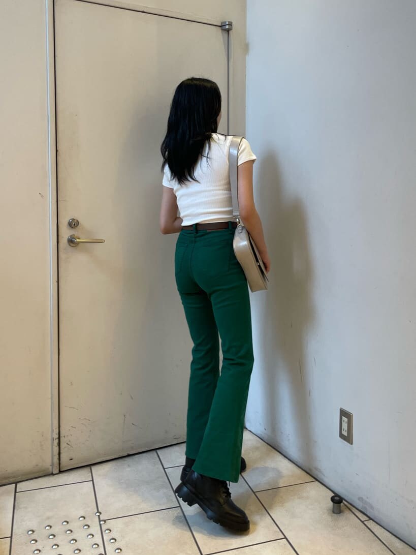 ブラック系のブーツ、ホワイト系のTシャツ/カットソー、グリーン系のデニムパンツを着用したレディースの春コーディネートの3枚目の写真