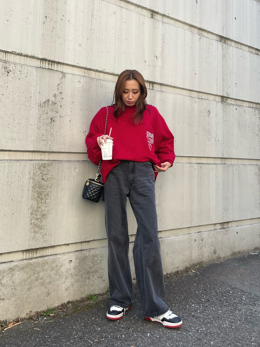 レッド系のスウェット、ブラック系のデニムパンツを着用したレディースの夏コーディネートの6枚目の写真