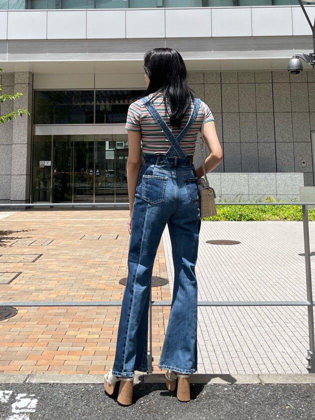 ブルー系のサロペット/オーバーオール、ホワイト系のサンダル、グリーン系のTシャツ/カットソーを着用したレディースの夏コーディネートの2枚目の写真