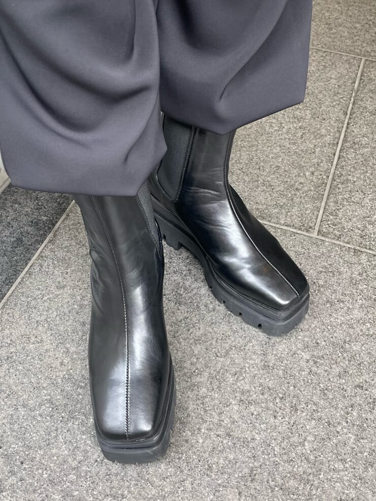 ブラック系のその他パンツ、グリーン系のTシャツ/カットソー、ブラック系のブーツを着用したレディースの春コーディネートの8枚目の写真