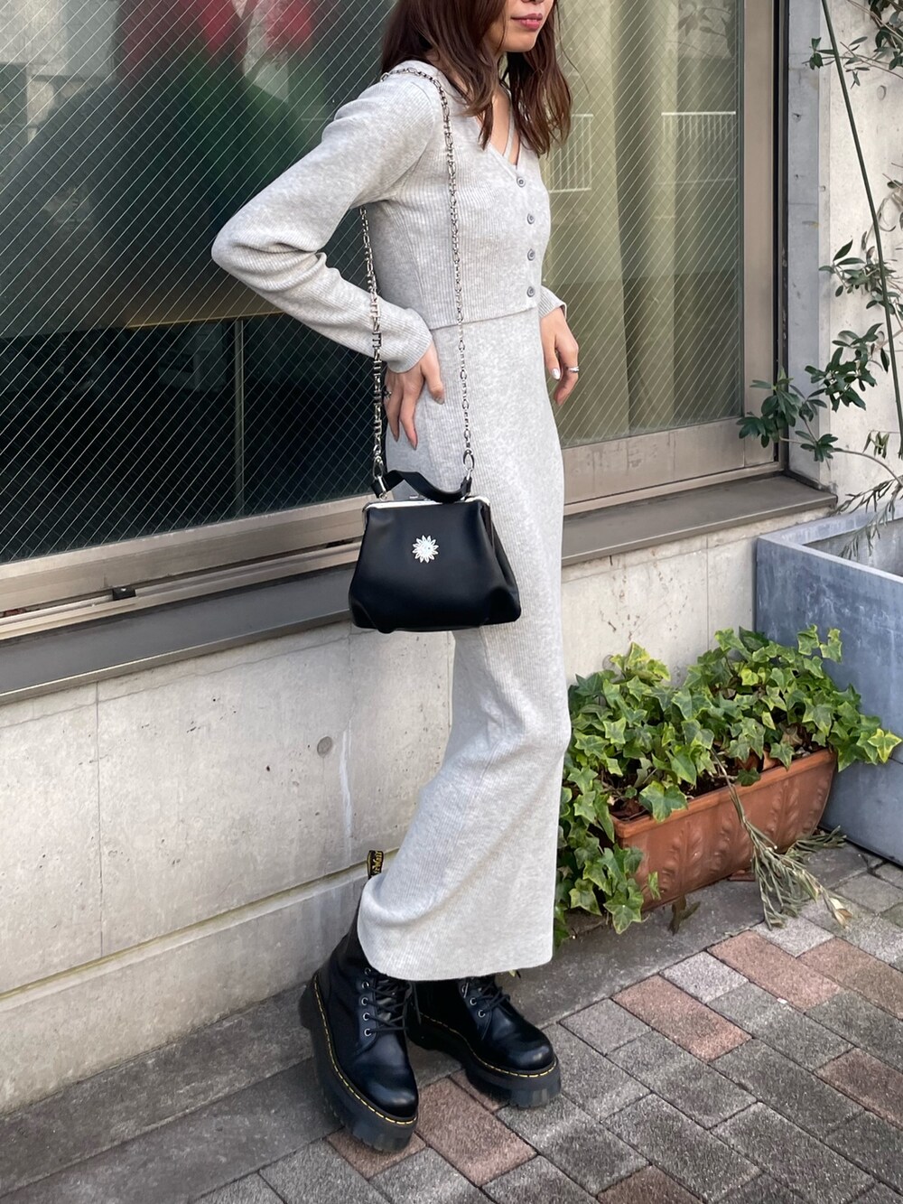 ブラック系のテーラードジャケット、グレー系のワンピース、ブラック系のショルダーバッグを着用したレディースの冬コーディネートの5枚目の写真