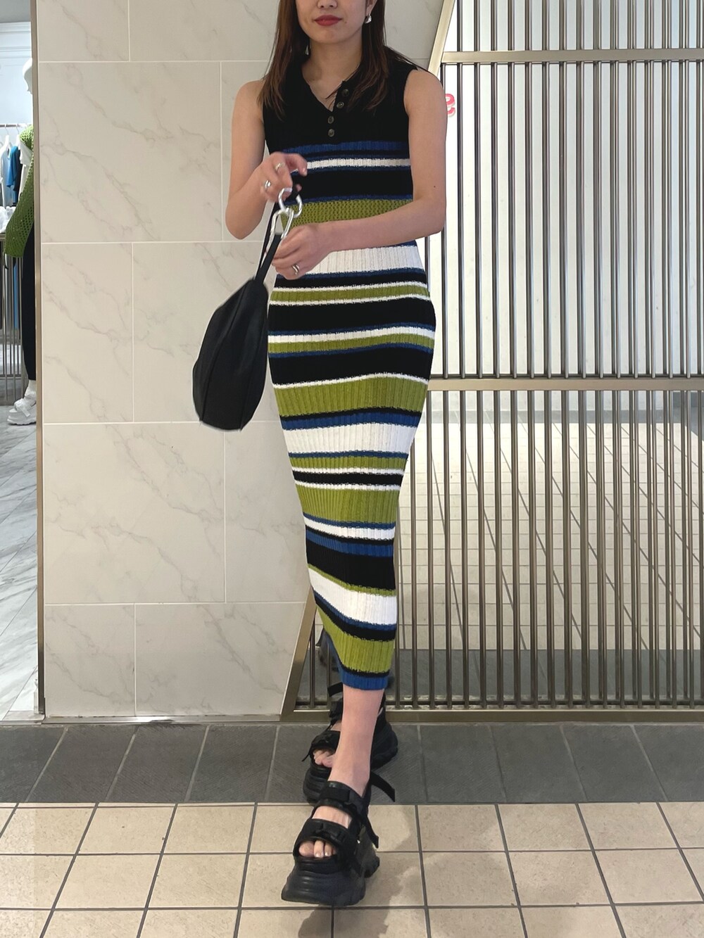 ブラック系のサンダル、ブラック系のワンピースを着用したレディースの春コーディネートの2枚目の写真