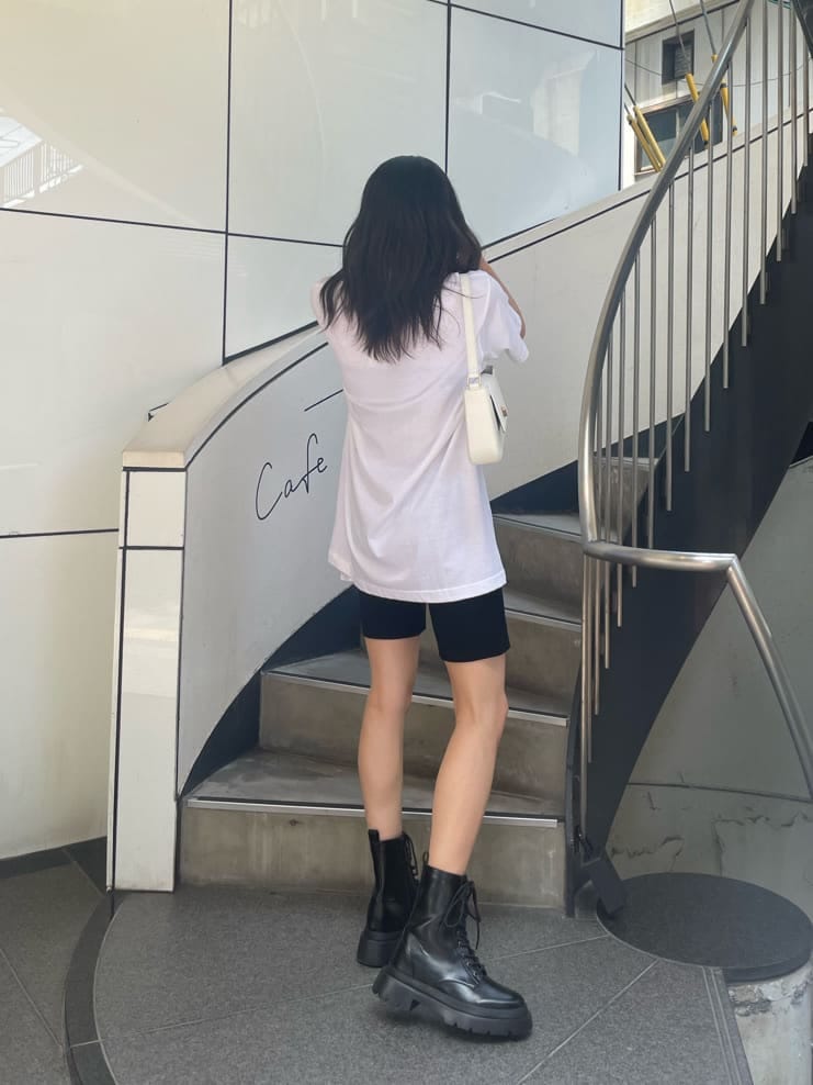 ブラック系のブーツ、ホワイト系のショルダーバッグ、ブラック系のその他パンツを着用したレディースの夏コーディネートの3枚目の写真